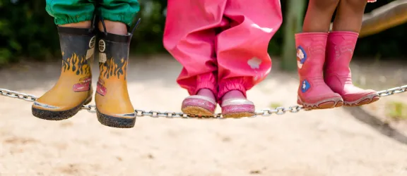Kindergartenkinder in Gummistiefel