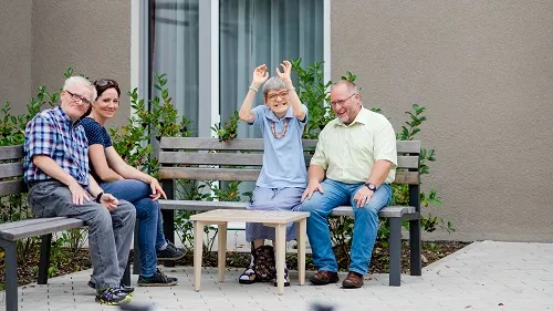 Vier Menschen sitzen im Freien auf zwei Bänken 