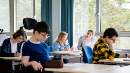 Schüler*innen und Lerhrerin im Klassenzimmer