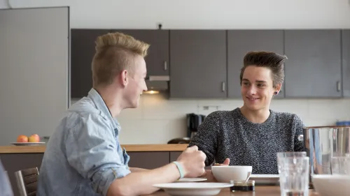 Zwei Jungen sitzen an einem Küchentisch und essen