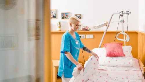 Eine Pflegerin macht gerade das Bett