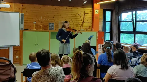 Franziska Hölscher spielt vor einer Klasse der Comenius-Schule am Auhof Geige. Gebannt lauschen die Schüler*innen der Musikerin. Foto: Rainer Kühlewind