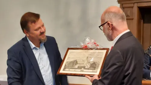 Altdorfs Bürgermeister Martin Tabor überreicht Diakon Thomas Jacoby einen Holzschnitt des historischen Gebäudes.